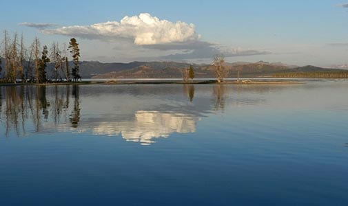 Serene waters of Yellowstone Lake reflecting the surrounding mountains